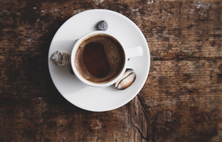 Image in retro style, dreaming of summer vacation, cup of coffee, shells, wooden backgroundの写真素材