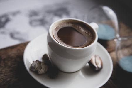 Image in retro style, dreaming of summer vacation, cup of coffee, seashells, sandglassの写真素材