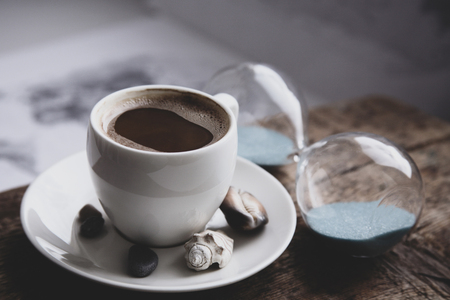 Image in retro style, dreaming of summer vacation, cup of coffee, seashells, sandglassの写真素材