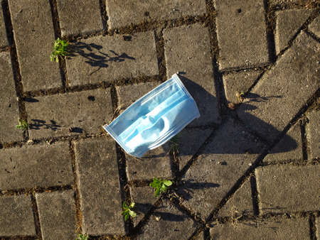 An anti surgical mask left on the groundの写真素材