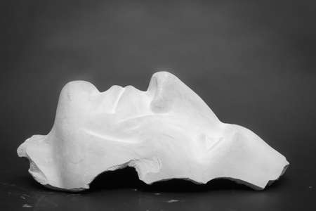 This is not a work of art. The author does not need a release. This is an ordinary plaster head used for teaching students at the Institute of Photography. Shooting in the studio on black background, black and white still life abstraction.の写真素材