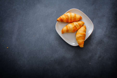 Delicious croissants on white square paper plate.の写真素材