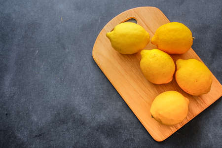 Food shot. Lemons Appetizing lemons, wooden board on a dark background.