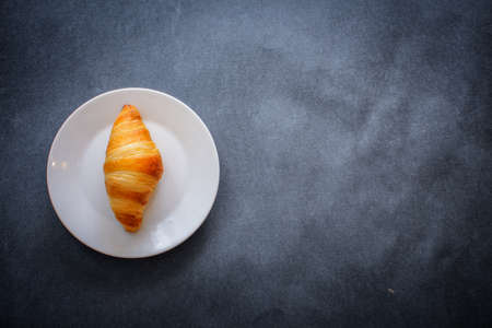 A rich variety of food photography Croissant. One delicious croissant on white dessert paper.の写真素材