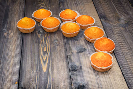 Festive composition for the background of New Year's postcards. A wooden table made of boards revealing a light turquoise tinge to some laid out freshly baked muffins.の写真素材