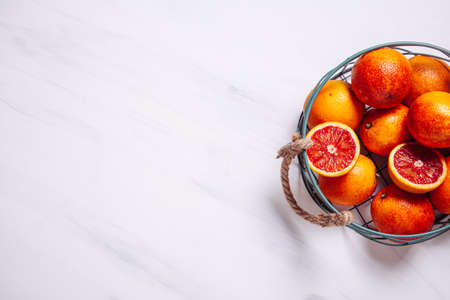 Sliced Sicilian blood oranges in a metal basket on a natural marble background. Top view. Flat lay, copy space.の写真素材