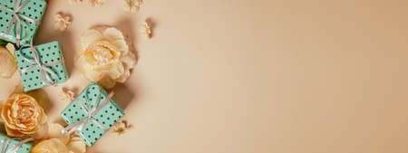 Valentine's Day background. Gift boxes with ribbons and roses on peach background. Valentine's day and birthday concept. International Women's Day. Flat lay, top view, copy space.の写真素材