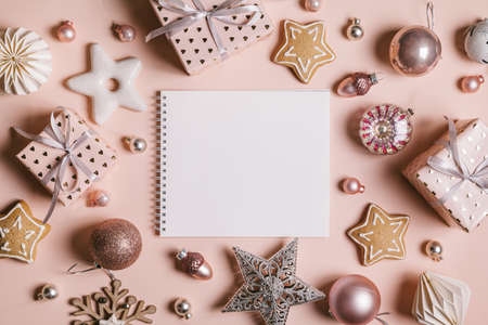 Christmas composition. Frame with gingerbread, gifts, Christmas decorations and an empty sheet for text on pastel pink background. Christmas, winter, new year concept. Flat lay, top view, copy space.の写真素材