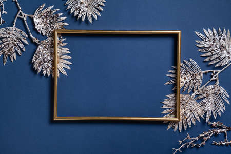 Christmas composition. Frame with golden branches on blue background. Christmas, winter, new year concept. Flat lay, top view, copy space.の写真素材