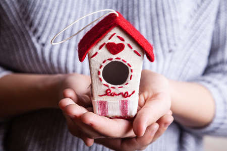 Handmade birdhouse in women's hands. Valentines day concept. Close up, copy space.の写真素材