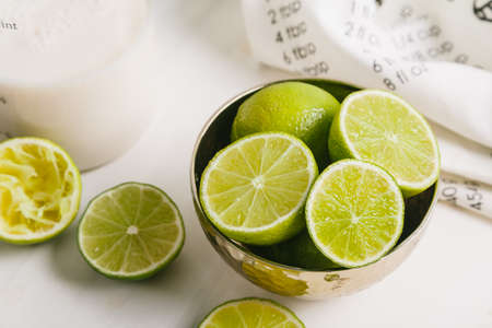Sliced limes in a plate on a white table. Close up.