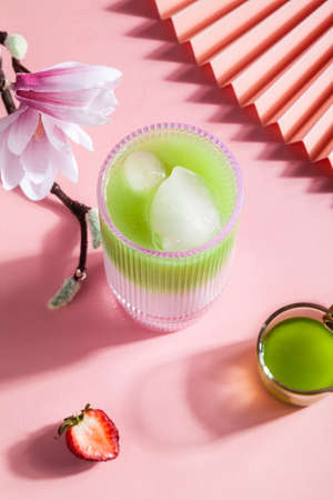 Strawberry matcha latte in a glass cup on a pink background.の写真素材