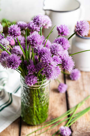 Schnitt-onion, chives flowers on a wooden background.の写真素材