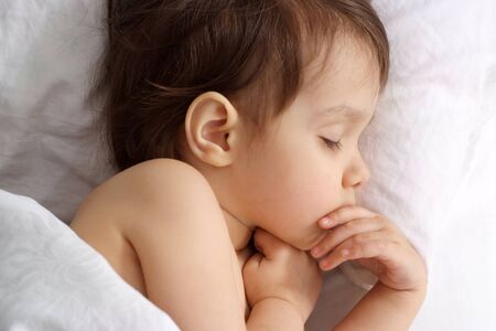 Amusing girl lying on bed at homeの写真素材