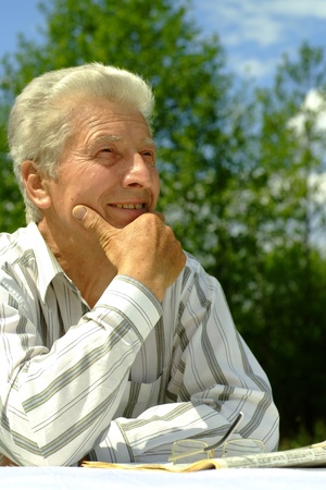 Beautiful Caucasian elderly man sitting with a tableの写真素材