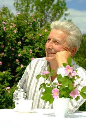 Beautiful Caucasian elderly man sitting with a tableの写真素材