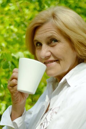 Beautiful Caucasian old woman with a cupの写真素材