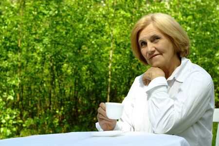 Beautiful Caucasian old woman with a cupの写真素材