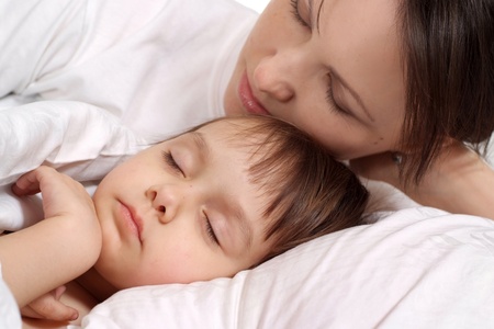 Little girl lying on bed at homeの写真素材