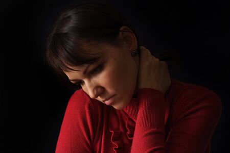 Good sad Caucasian woman sitting on a dark backgroundの写真素材