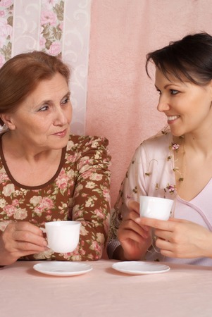 older woman with her adult daughter on a pink backgroundの写真素材