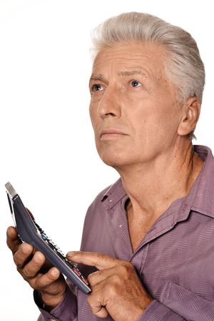 Serious elderly man with calculatorの写真素材