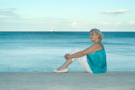 Portrait of a happy elderly woman on a background of the seaの写真素材