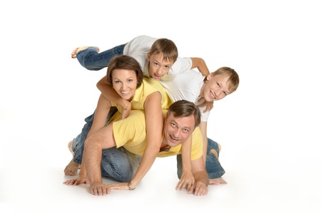 Happy family climbing on top of each other on the floorの写真素材