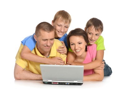 Happy family with laptop on a floorの写真素材