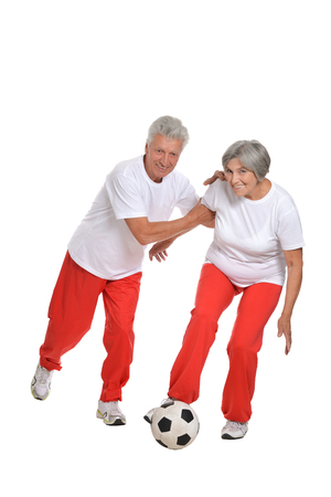 Elderly couple standing with a ball in a gymの写真素材