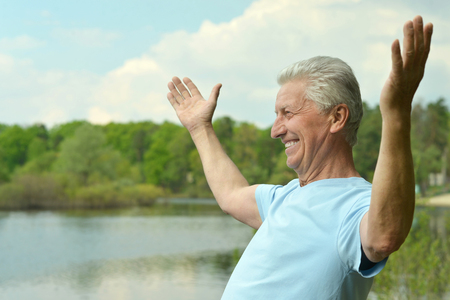 Nice elderly man went to the river to relaxの写真素材