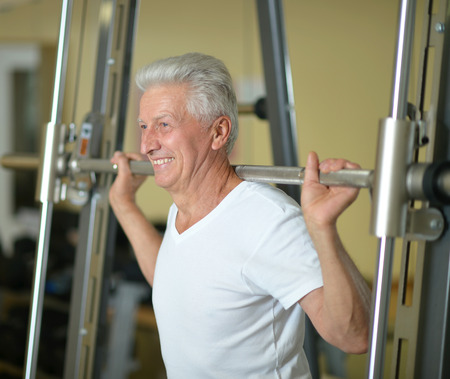 Elderly man doing sports in a gymの写真素材