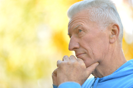 Portrait of senior man thinking about something outdoorの写真素材