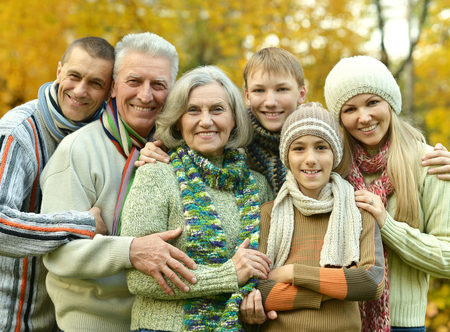 Happy smiling family relaxing in autumn parkの写真素材