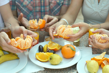 Portrait of hands holding ripe tangerine close-upの写真素材
