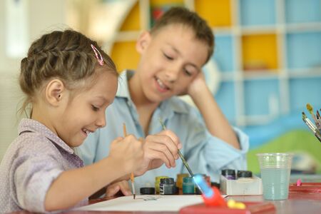 Little girl with boy drawing at homeの写真素材