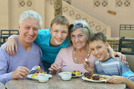 Grandparents with grandchildren at breakfast on tropical resort
