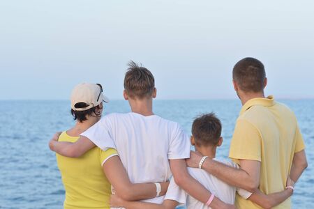 Family at beach in summer back viewの写真素材