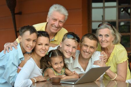 Happy family sitting with laptop on table