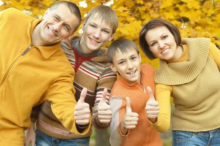 Portrait of happy family relaxing in autumn parkの写真素材