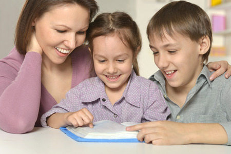 Mother  help children do their homework at tableの写真素材