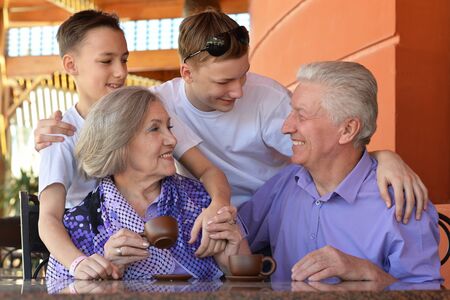 Happy family at table outdoors in summer timeの写真素材