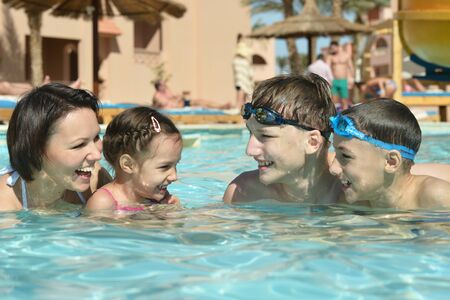 Portrait of a happy family having fun in poolの写真素材