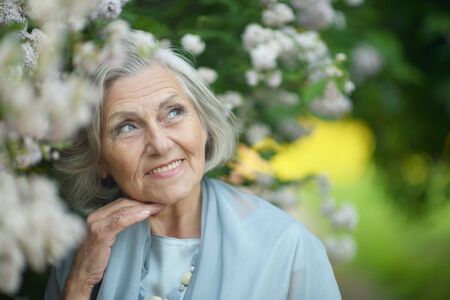 Portrait of a beautiful senior woman in green parkの写真素材