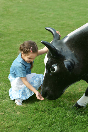 Portrait of a little girl and cowの写真素材