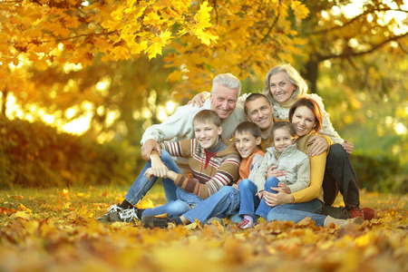 Happy smiling family sitting in autumn parkの写真素材