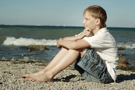 Portrait of a happy boy in a white T-shirt on summer vacationの写真素材
