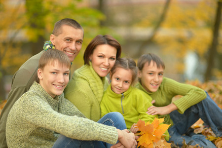 Happy smiling family relaxing in autumn parkの写真素材