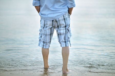 Legs of man  walking on beach closeupの写真素材