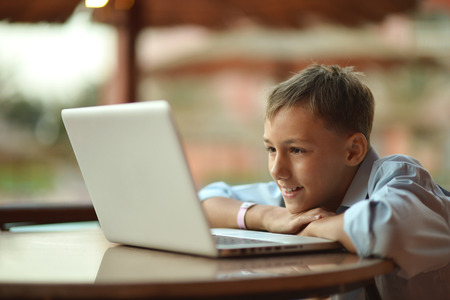 Portrait of a  boy with laptop on table